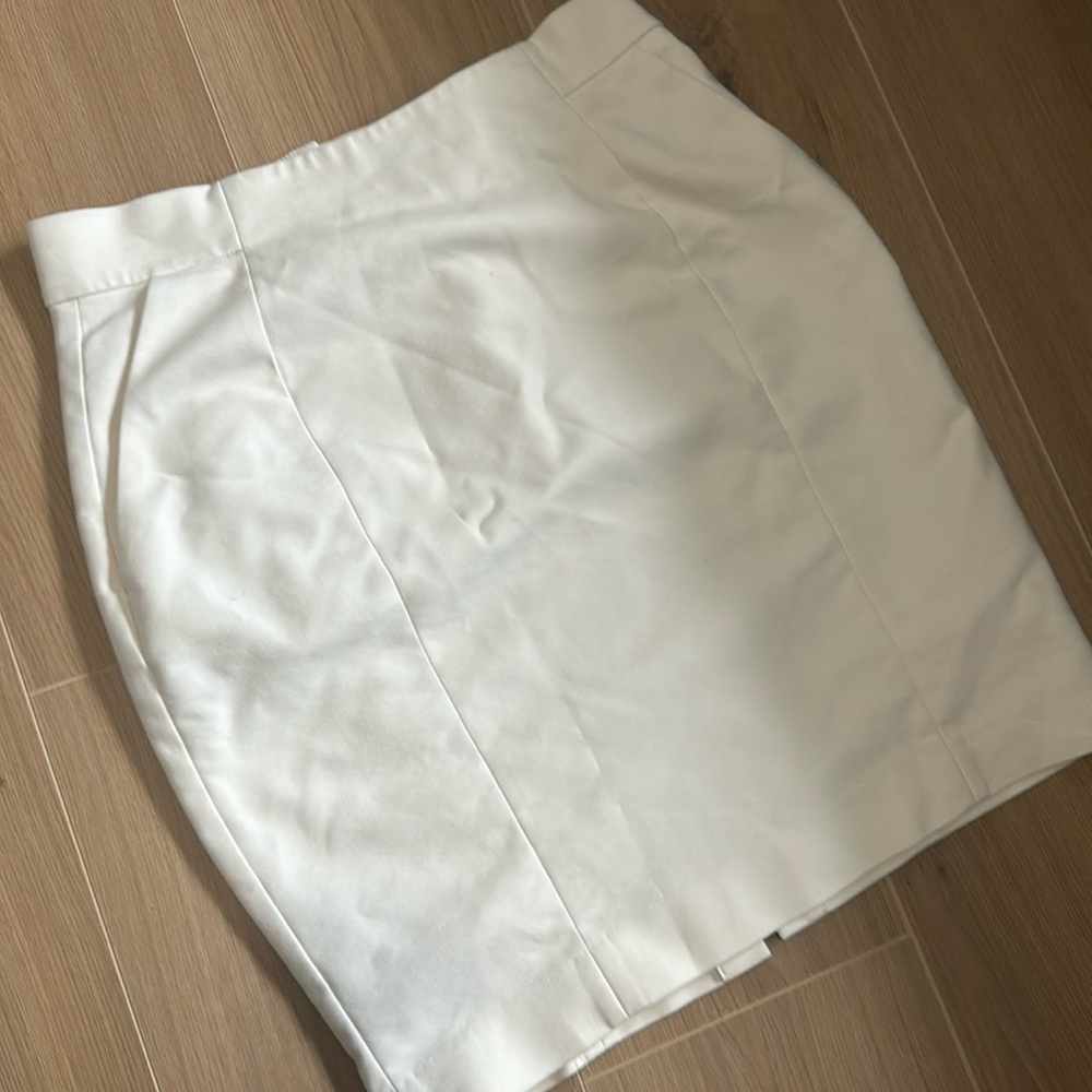 Cream knee length skirt with pockets.